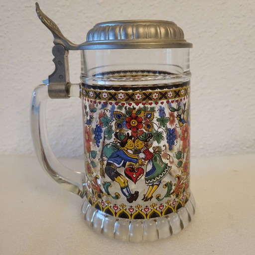 Bierkrug aus Glas mit folkloristischen Motiven verziert