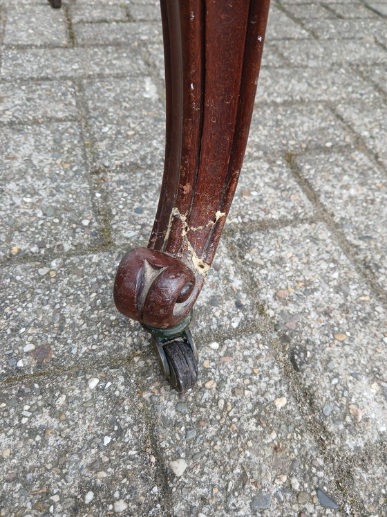 Image 1 of The antique dining table is made of mahogany and has a Louis XV style.