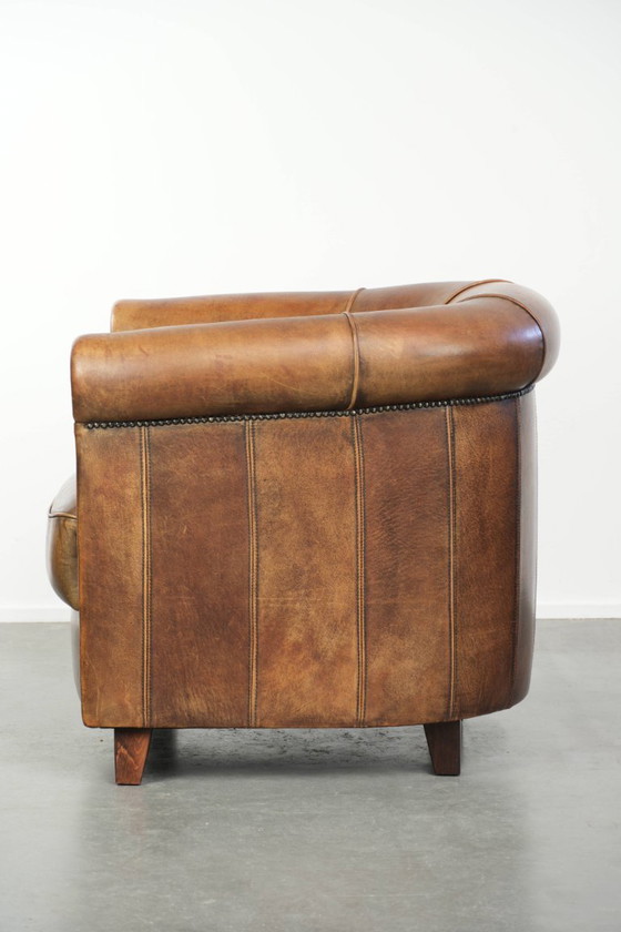 Sturdy and characterful sheepskin club armchair with a beautiful patina, finished with decorative nails. (photo 5 of 12)