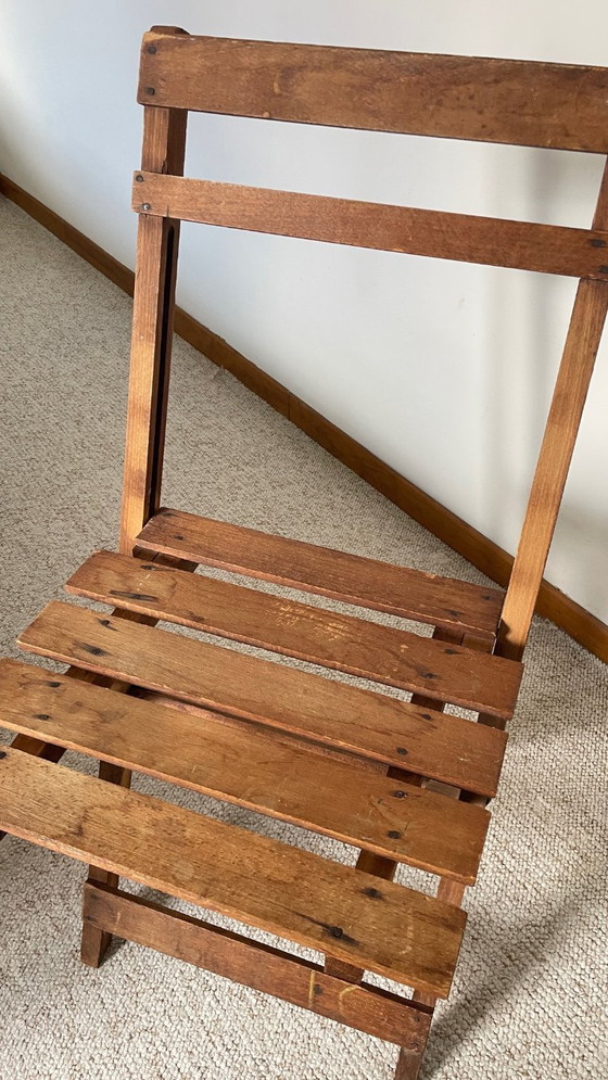 Image 1 of Antieke opklapbare houten stoel, een praktische en geometrische zitplaats. We zijn helemaal gecharmeerd van deze antieke stoel.