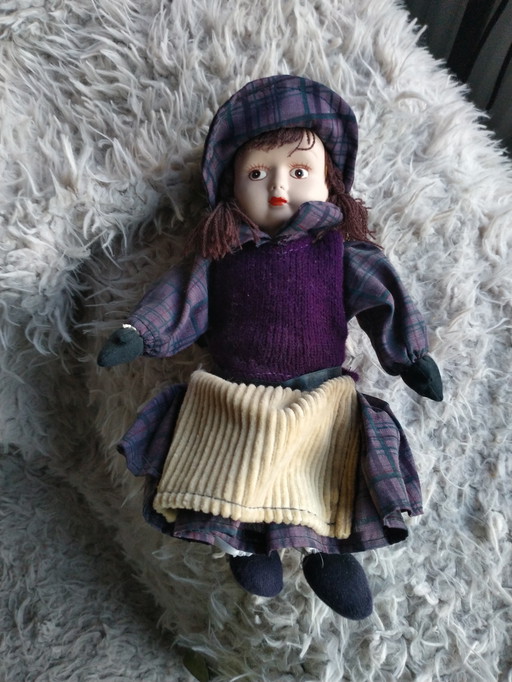 Two genuine porcelain dolls on an original wicker chair