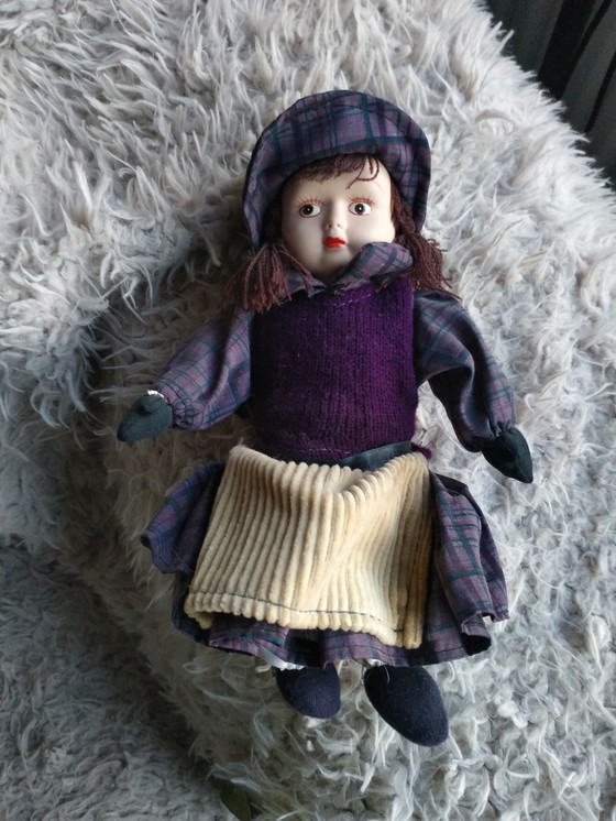 Image 1 of Deux véritables poupées en porcelaine sur une chaise en osier originale