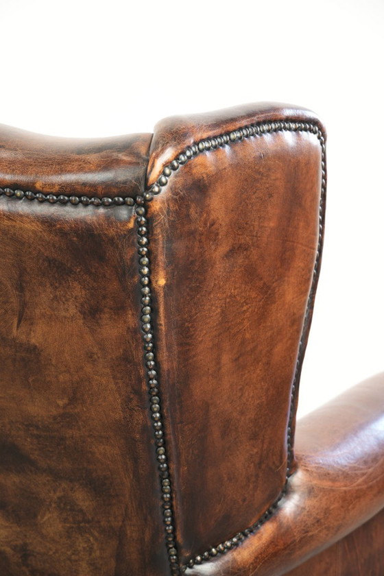 Ruime vintage schapenleren oorfauteuil in een diepe bruine kleur afgewerkt met siernagels – Leather (photo 17 of 17)