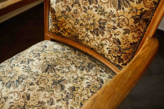 Image 1 of Vintage salonfauteuil met bloemenpatroon op de bekleding en sierlijke armleuningen.