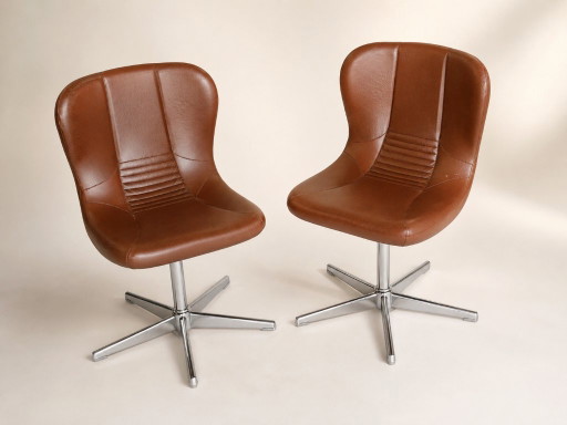 Een paar draaibare fauteuils uit de jaren 60/70 in bruin kunstleer en verchroomd metaal, vintage stoelen in de stijl van het mid