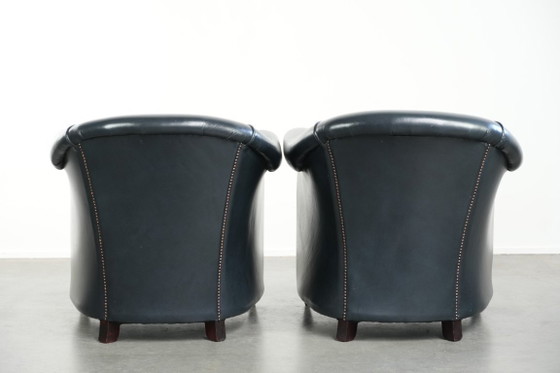 Image 1 of 2 comode poltrone club in pelle bovina blu scuro dal design unico e senza tempo.