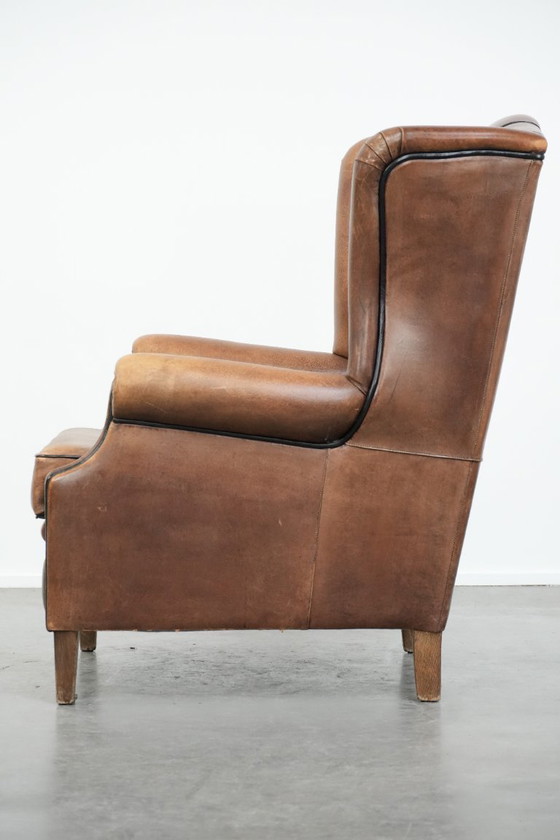 Image 1 of Poltrona a orecchioni in pelle di pecora con profili neri, in buone condizioni.