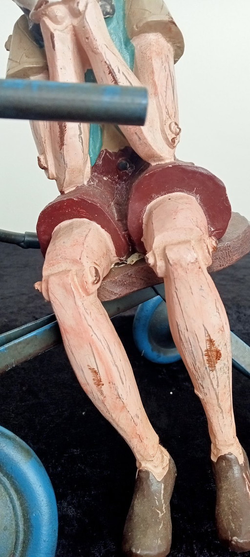 Objet de collection : Statue artisanale de Pinocchio sur un tricycle