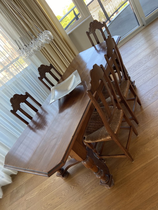 Mesa de castillo antigua con 6 sillas y asiento de mimbre.