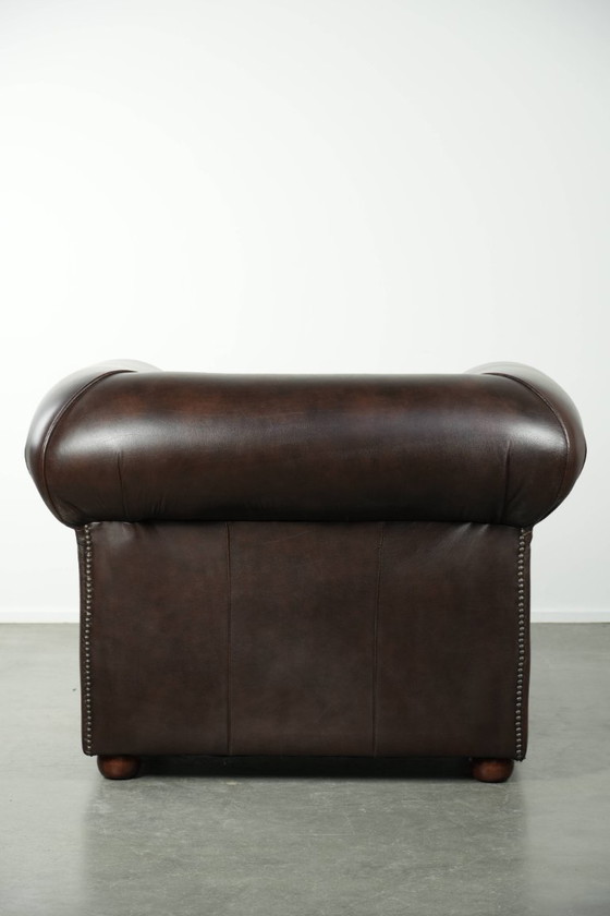 Image 1 of Conjunto de lujo de piel de vacuno marrón compuesto por un sofá Chesterfield liso y un sillón.