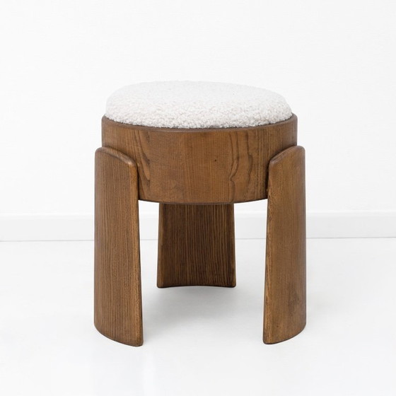Image 1 of Een paar Art Deco-stijl krukjes van essenhout, bekleed met witte boucléstof.