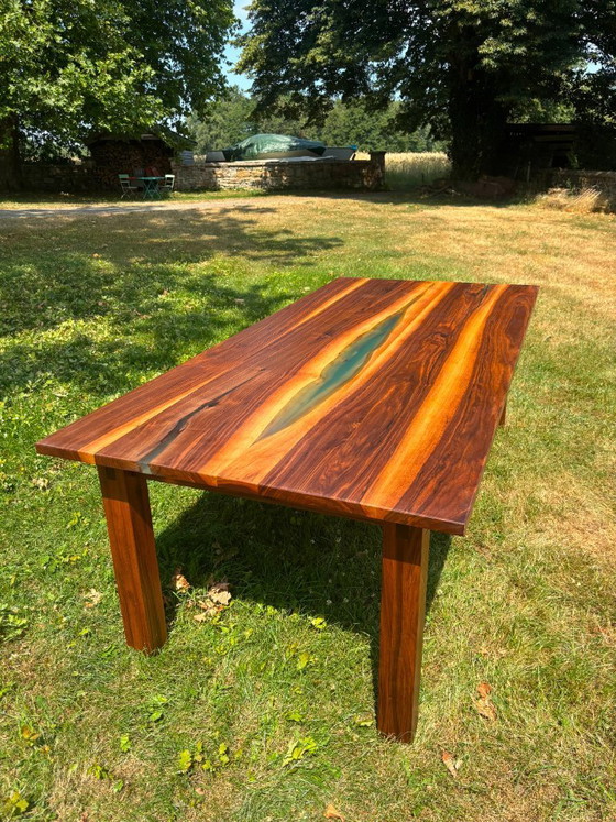 Image 1 of Dining table in American walnut and maple. Handcrafted solid wood extensions and drawers. Live edge for visual depth. Epoxy resi