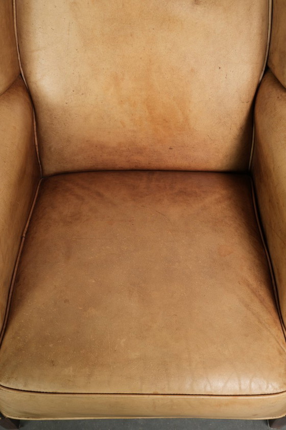 Image 1 of Dos hermosos sillones orejeros de piel de vaca clara con un estilo inglés atemporal y gran comodidad.