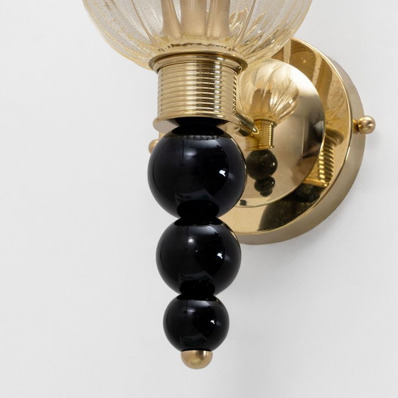 Image 1 of Een paar Italiaanse wandlampen van Murano-glas met goudstofaccenten en messing.