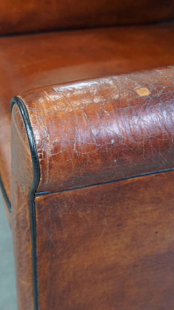 Image 1 of 2 x Vintage schapenleren eetkamerstoel met zwarte biezen op wieltjes