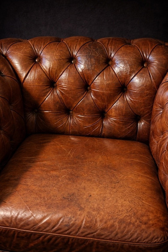 Image 1 of POLTRONA CHESTERFIELD CON POUF IN PELLE PATINA COGNAC