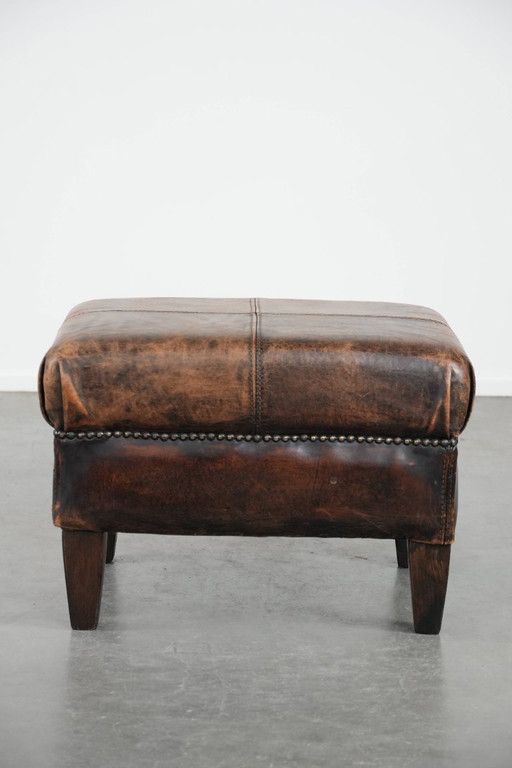 Taburete vintage de piel de oveja con hermosos colores.