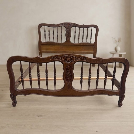 Struttura letto vintage in legno intagliato, con testiera e pediera ornamentali, prima metà del XX secolo.