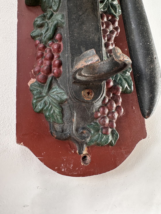 Image 1 of Ouvre-bouteille mural ancien en fonte à motif de raisin – style auberge (vers 1900)