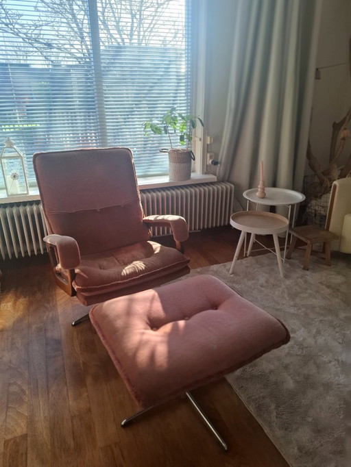 Sessel und Hocker im Stil der 70er Jahre in Altrosa. Beide stehen auf stabilen Metallbeinen und sind um 360° drehbar.