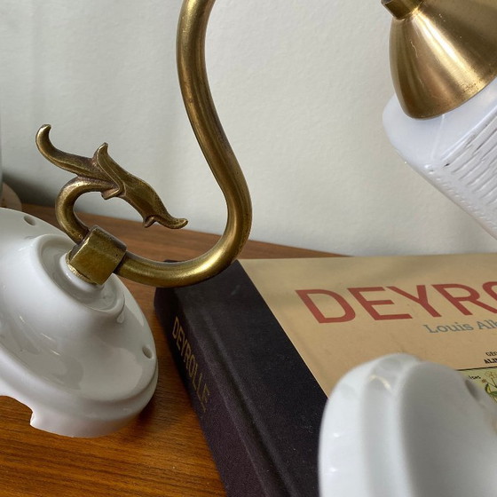 Image 1 of Pair of brass gooseneck wall lights with white glass and porcelain mounting rosettes