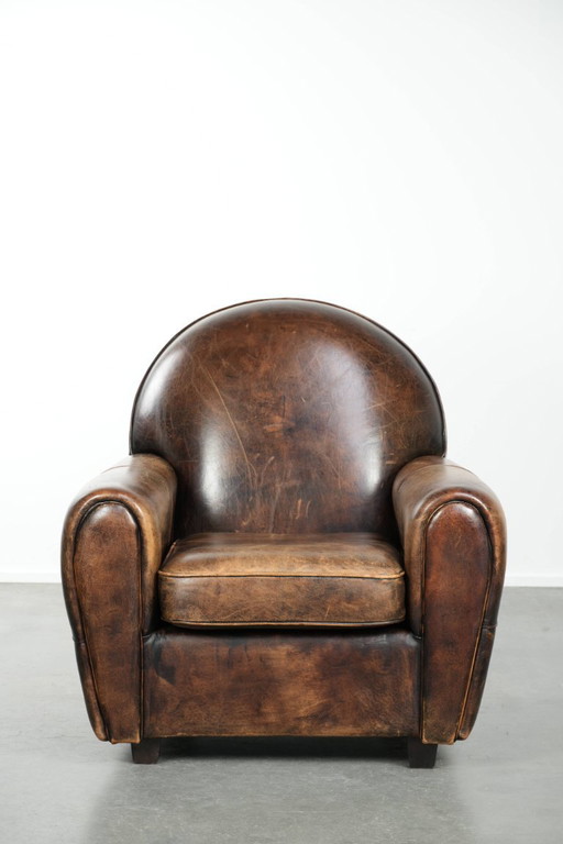 Elegante poltrona dal design Art Déco, rivestita in comoda pelle di pecora.