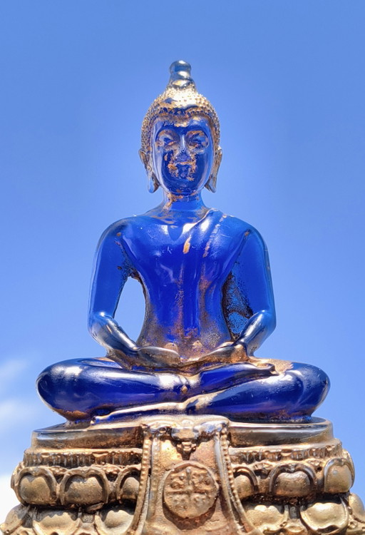 Old Buddha made of blue glass and stone material.
