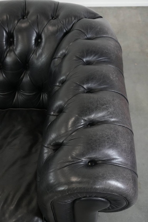 Image 1 of Set consisting of a black Chesterfield sofa, armchair and footstool made of cowhide