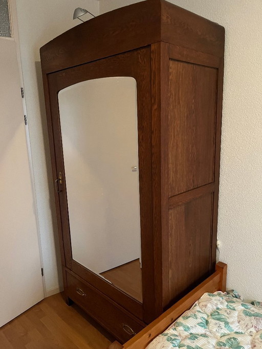 Armario antiguo de madera con puerta de espejo