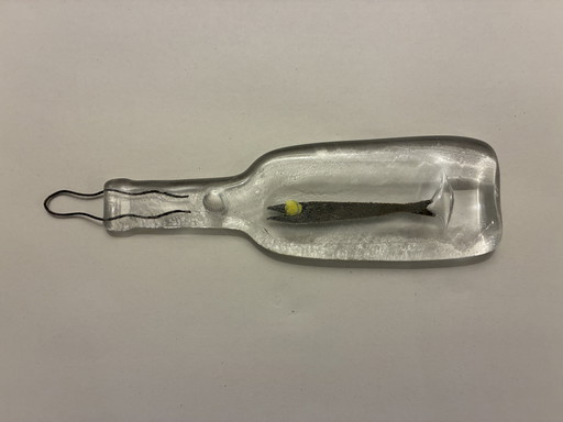 Bottle made of pressed glass with incorporated decorative fish and shell