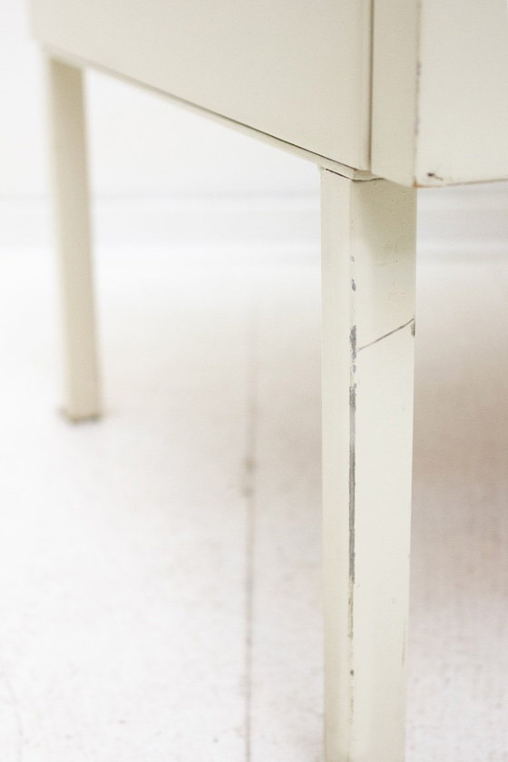 Image 1 of Mesita de noche de madera Interlübke con patas de metal lacado en blanco.
