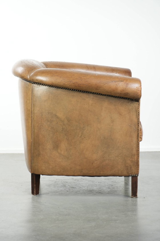 Image 1 of Vintage sheepskin club armchair with beautiful colors and finished with decorative nails.