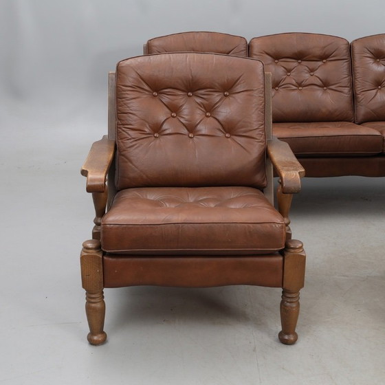 Image 1 of A vintage brown three-piece sofa set in leather with wooden armrests and turned legs, comprising a 1-seater, 2-seater and 3-seat