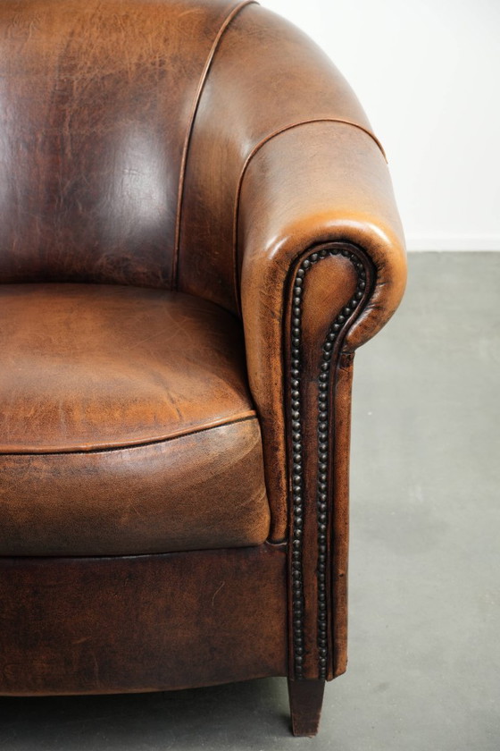 Image 1 of Karaktervolle en comfortabele clubfauteuil gemaakt van schapenleer met een vast zitkussen en uitmuntende kleuren