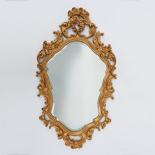 French Rococo or Baroque style facet-cut crest mirror in gilded carved wood