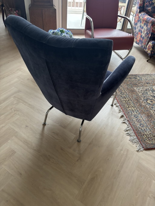 Moderne fauteuile in de kleur korenblauw fluweel,met roomkleurige lederen details in de rugleuning, met chroom poten.