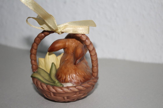 Image 1 of Un conejito adorable en una cesta con una flor amarilla. Goebel Edición Limitada Sorpresa de Pascua 2001