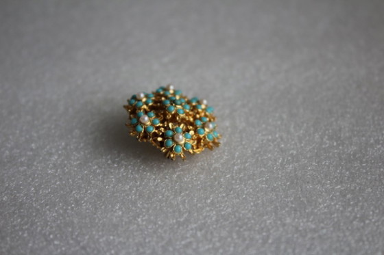 Image 1 of Ronde vintage broche, goudkleurig metaal met kleine groene en witte parels.