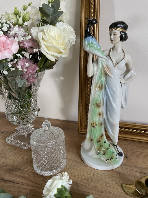 Vintage sculpture of a woman with a peacock