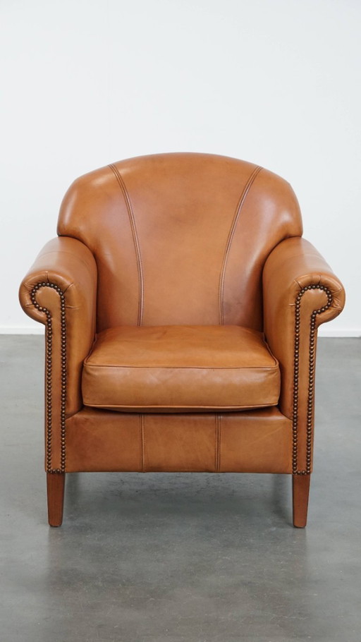 Rundleren fauteuil/ armchair in cognac kleur afgewerkt met siernagels