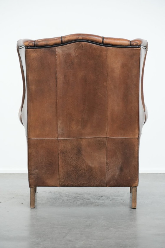 Image 1 of Poltrona a orecchioni in pelle di pecora con profili neri, in buone condizioni.