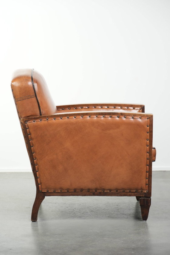 Image 1 of Schapenleren art Deco fauteuil met mooi houtsnijwerk en zwarte biezen