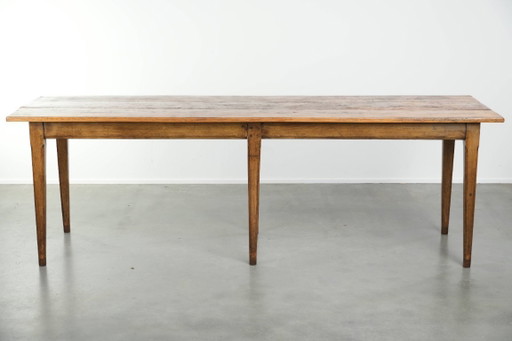Large, relatively narrow antique French farmhouse dining table made of pine from the early 19th century with a beautiful patina.