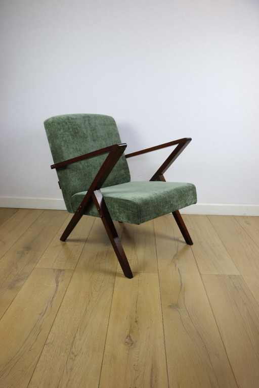 Vintage loft-fauteuil in olijfgroen, net als een spijkerbroek.