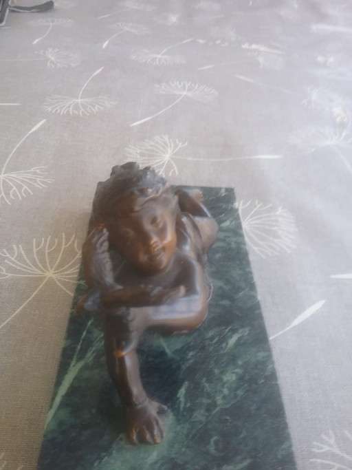 Statuetta in bronzo raffigurante un ragazzo con un uccello in mano.