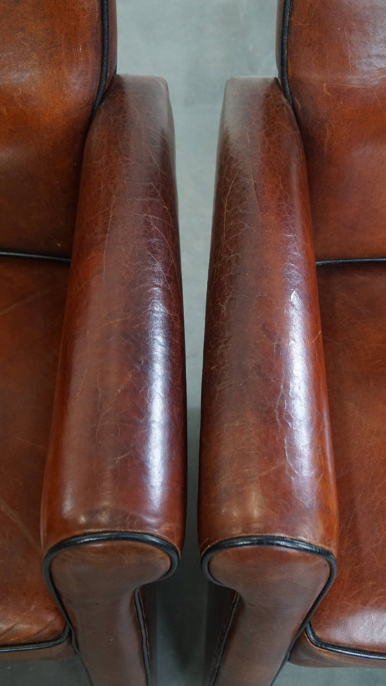 Image 1 of 2 x Vintage schapenleren eetkamerstoel met zwarte biezen op wieltjes