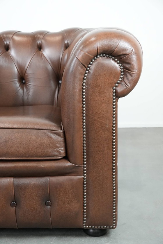 Image 1 of Impresionante sillón Chesterfield de piel de vaca marrón al estilo inglés, acabado con clavos decorativos.
