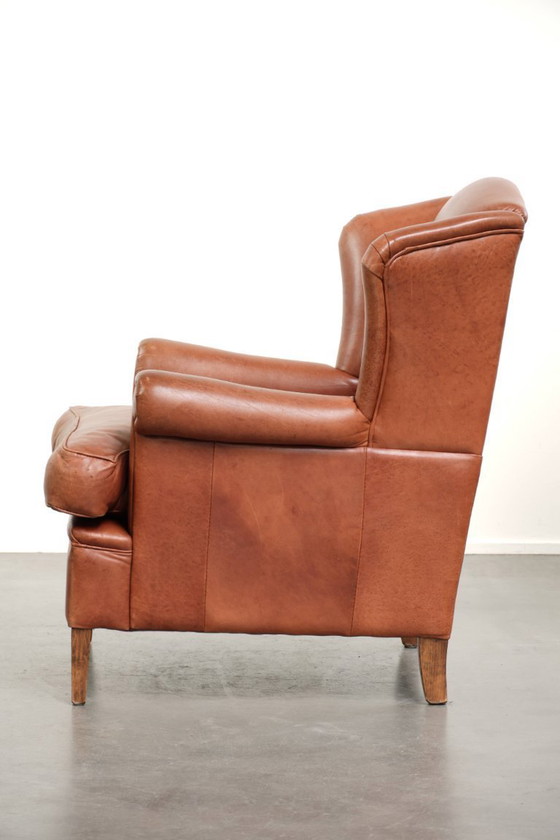 Image 1 of Poltrona a orecchioni color cognac chiaro, rivestita in pelle bovina, dal caratteristico look inglese.