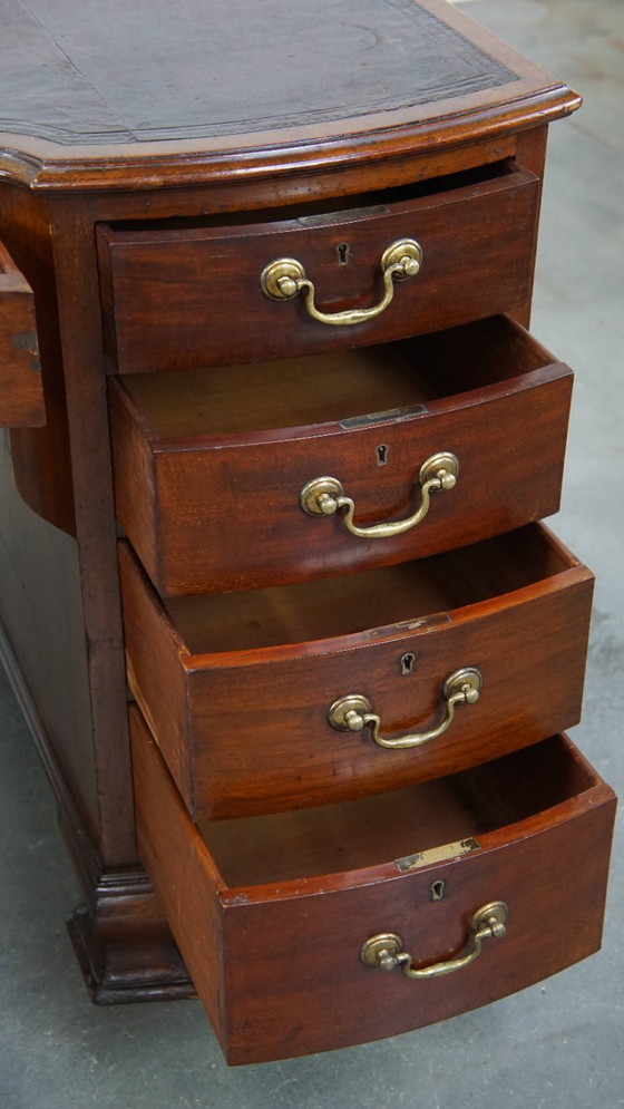 Image 1 of Luxurious and antique English wooden desk from the late 19th century with a leather top and a curved front.