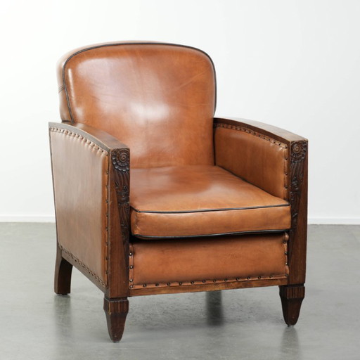 Unieke schapenleren art Deco fauteuil met mooi houtsnijwerk en zwarte biezen